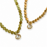Two beaded necklaces with crystal pendants on a white background