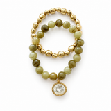 golden bead and marbled olive color bead bracelet with a crystal charm, bracelet set on white background