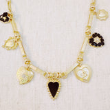Gold-tone necklace featuring a collection of heart-shaped charms in black and gold finishes—creating a romantic, vintage-inspired statement with a bold, elegant touch.