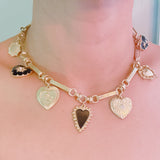 Gold-tone necklace featuring a collection of heart-shaped charms in black and gold finishes—creating a romantic, vintage-inspired statement with a bold, elegant touch.