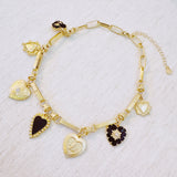 Gold-tone necklace featuring a collection of heart-shaped charms in black and gold finishes—creating a romantic, vintage-inspired statement with a bold, elegant touch.