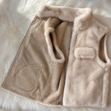 A beige faux fur vest with a matching beige corduroy-like front panel and soft lining, laid flat on a white faux fur background.