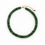 A green beaded necklace made of faceted round beads, arranged in a circle on a white background, with a gold-tone chain extender and clasp.