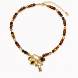 Necklace with brown beads and gold charms on a white background