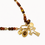 Necklace with brown beads and gold charms on a white background