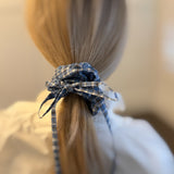 Stylish hair scrunchie featuring a classic plaid pattern with long, flowing tails—perfect for a polished, preppy look with a playful twist.