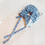 Stylish hair scrunchie featuring a classic plaid pattern with long, flowing tails—perfect for a polished, preppy look with a playful twist.