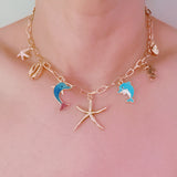 Gold necklace with starfish, shell, and colorful ocean-themed charms