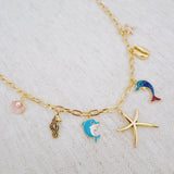 Gold necklace with starfish, shell, and colorful ocean-themed charms