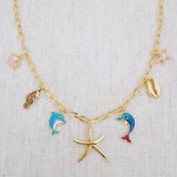 Gold necklace with starfish, shell, and colorful ocean-themed charms