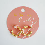 Polished gold hoop earrings adorned with small white pearls evenly spaced around the hoop. The design combines modern structure with classic pearl accents for a refined yet trendy look.