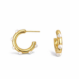 Polished gold hoop earrings adorned with small white pearls evenly spaced around the hoop. The design combines modern structure with classic pearl accents for a refined yet trendy look.
