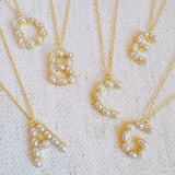 Gold chain necklace featuring an elegant initial pendant inlaid with pearl mosaic accents for a personalized, sophisticated touch.