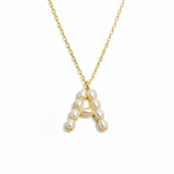 Gold necklace with a pendant shaped like the letter 'A' on a white background