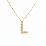 Gold necklaces with pearl beads on a initial pendant L with white background