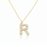 Gold necklaces with pearl beads on a initial pendant R with white background