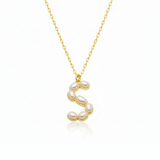 Gold necklace with pearl beads on a pendant S with a white background