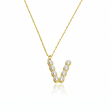 Gold necklace with a pendant initial V featuring pearls on a white background