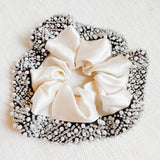 Elegant satin hair scrunchie embellished with delicate pearls and beads—adding a touch of sophistication and shine to any hairstyle.