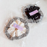 Elegant satin hair scrunchie embellished with delicate pearls and beads—adding a touch of sophistication and shine to any hairstyle.