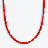 Close-up of a bold red beaded necklace featuring uniformly round, glossy beads strung together in a classic strand, creating a vibrant and timeless accessory.