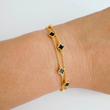 Delicate layered chain bracelet featuring a petite clover charm centerpiece, offering a minimalist and feminine touch with a refined gold-tone finish.