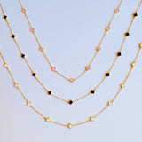 Gold-toned necklace featuring a delicate colored clover pendant, suspended on a fine chain for a soft pop of charm and color.