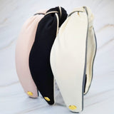 Structured preppy headband featuring a contrasting piped border detail, adding a polished and classic touch to any hairstyle.