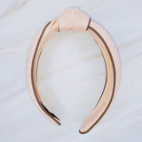 Structured preppy headband featuring a contrasting piped border detail, adding a polished and classic touch to any hairstyle.