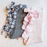 Set of two socks featuring plaid patterns with ruffle bow accents, combining classic charm with playful, feminine details.