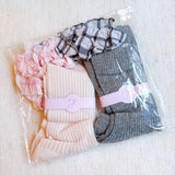 Set of two socks featuring plaid patterns with ruffle bow accents, combining classic charm with playful, feminine details.