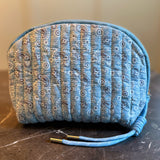Quilted cosmetic case featuring a colorful paisley pattern and zip closure, combining stylish design with soft, padded texture for everyday beauty storage.