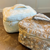 Quilted velvet vanity bag with top handle and zipper closure, available in creamy velvet and vintage moss color variants