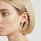Elegant stud earrings featuring a brilliant clear crystal paired with a small luminous pearl in a gold-tone setting. The dual-stone design combines modern sophistication with timeless charm, perfect for everyday wear or special occasions.