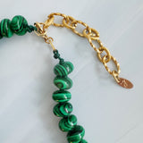 A collection of polished gemstone bead necklaces in various colors, including deep blue, green, brown, pink, and cream. Each necklace features smooth, rounded beads with a glossy finish, offering a timeless and versatile accessory look.