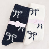 Set of two fuzzy socks featuring playful bow accents, combining cozy comfort with a touch of sassy, feminine charm.