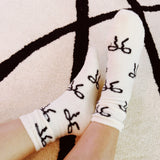 Set of two fuzzy socks featuring playful bow accents, combining cozy comfort with a touch of sassy, feminine charm.