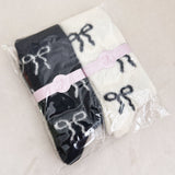 Set of two fuzzy socks featuring playful bow accents, combining cozy comfort with a touch of sassy, feminine charm.