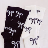 Set of two fuzzy socks featuring playful bow accents, combining cozy comfort with a touch of sassy, feminine charm.