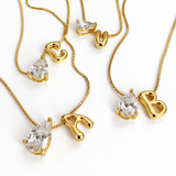 Sculptural Initial Pear Crystal Necklaces – Assorted Gold Letter Charms with Pear-Cut Crystal, Flat Lay