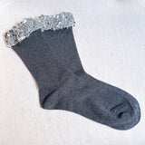 Sparkly socks featuring a sequin-embellished top band, adding a touch of chic shine and glam to any outfit.