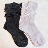 Set of two shimmer socks featuring delicate bow embellishments, designed in a chic, sparkly finish for a stylish and feminine touch.