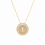 Gold necklace with a circular pendant featuring a cross on a white background