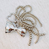 Shiny silver bow charm and cascading bead tassels – glam and elegant