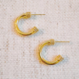 Minimalist gold-tone hoop earrings with a smooth, polished finish and classic round shape, perfect for everyday wear.