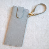 Sleek glass case bag charm with a button-up closure and strap attachment, offering a stylish and convenient way to carry your glasses on the go.