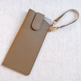 Sleek glass case bag charm with a button-up closure and strap attachment, offering a stylish and convenient way to carry your glasses on the go.