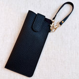 Sleek glass case bag charm with a button-up closure and strap attachment, offering a stylish and convenient way to carry your glasses on the go.