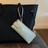 Sleek glass case bag charm with a button-up closure and strap attachment, offering a stylish and convenient way to carry your glasses on the go.