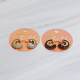 A pair of small gold-tone hoop earrings encrusted with sparkling rhinestones